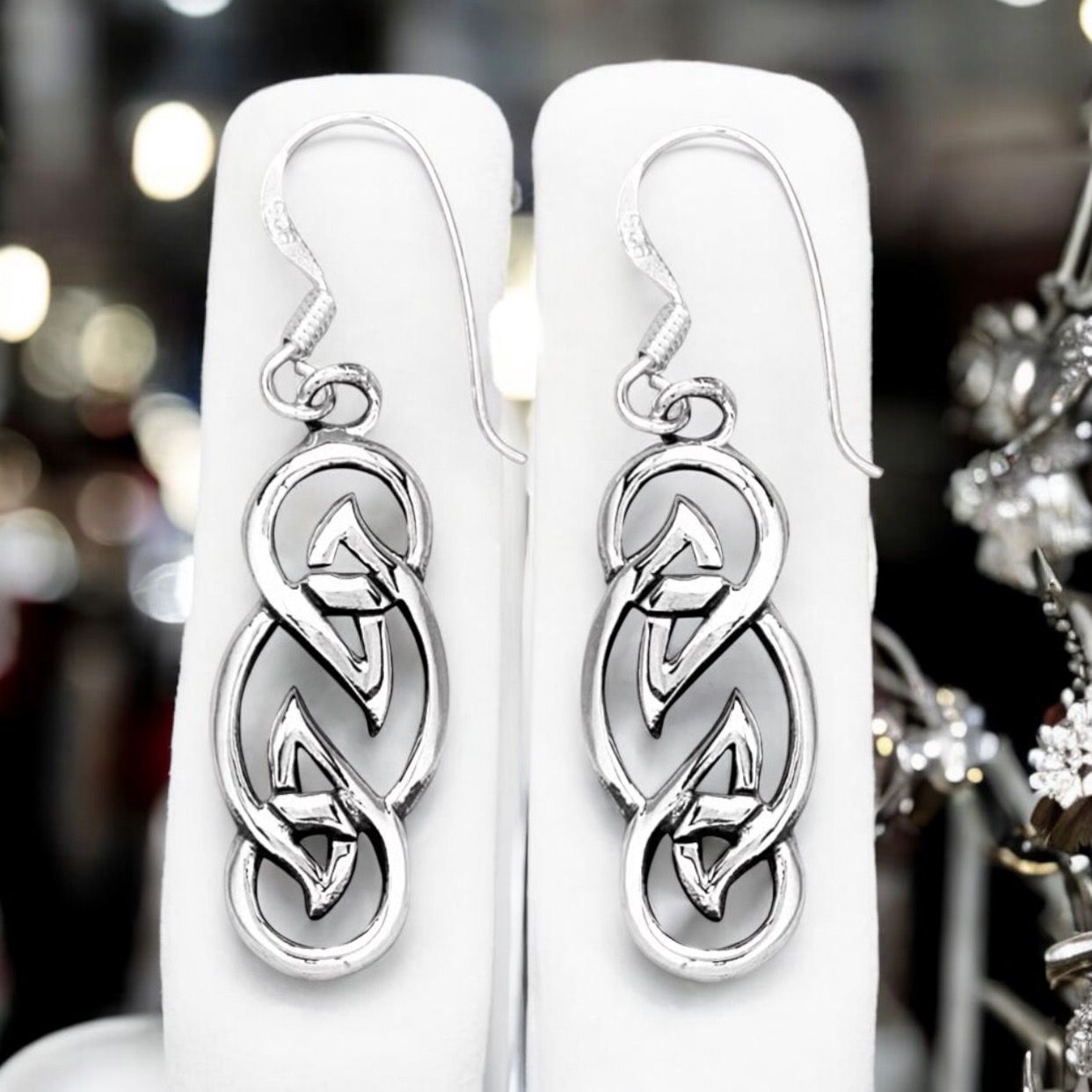 Sterling silver Celtic knot weave earrings celebrating timeless Celtic symbolism and heritage. Shown on earrings holder. 