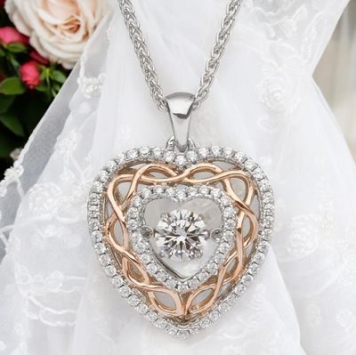 Sterling silver Celtic heart pendant with rose gold plated knotwork and sparkling CZ stone, celebrating Celtic heritage.