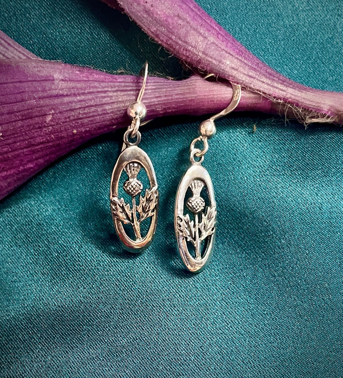 Elegant sterling silver oval thistle earrings on purple leaf, Scottish heritage jewelry for her