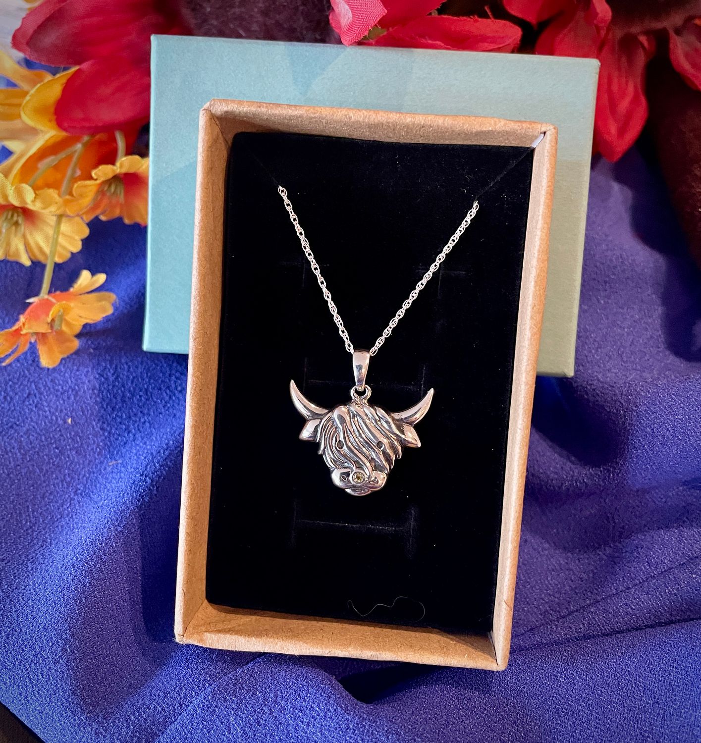Sterling silver Scottish Highland Cow pendant, handcrafted Celtic jewelry from Scotland, shown in jewelry box. 
