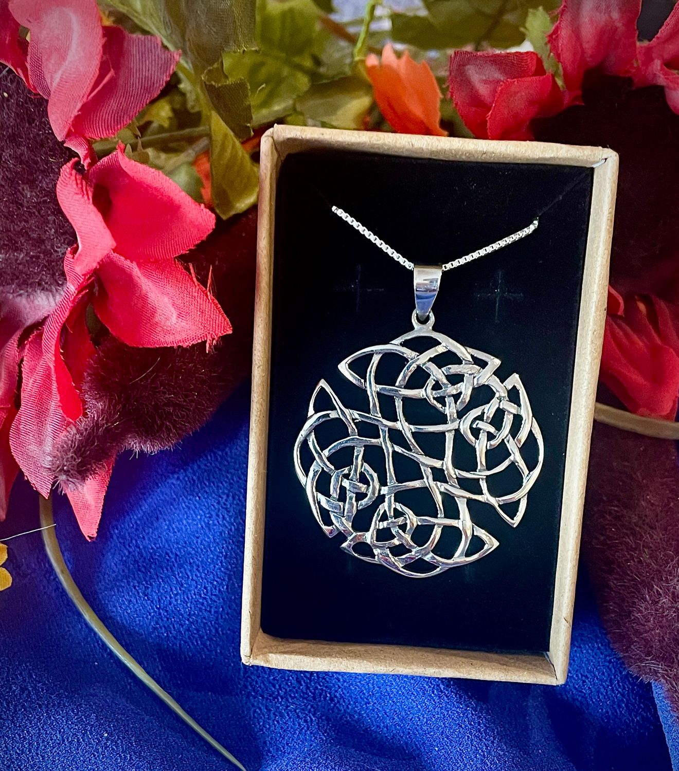 Large sterling silver Celtic knot pendant, symbolic jewelry representing eternity and interconnectedness, in jewelry box.