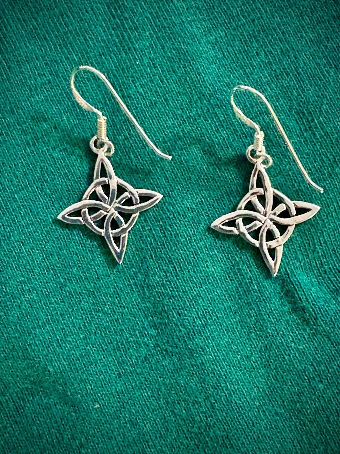 Sterling Silver Witch's Knot Hexefus Earrings on Green Fabric. 