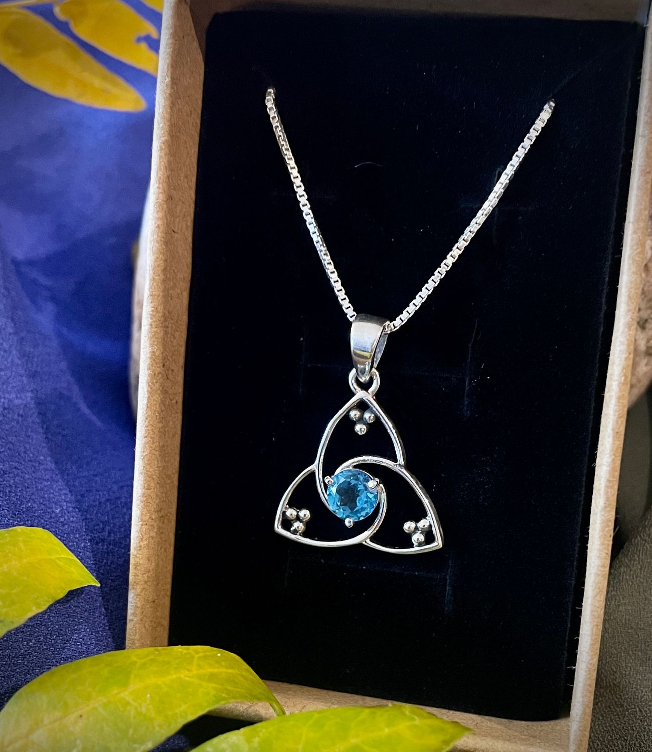 Celtic Trinity Knot necklace in sterling silver with blue sapphire gemstone, perfect for September birthdays.