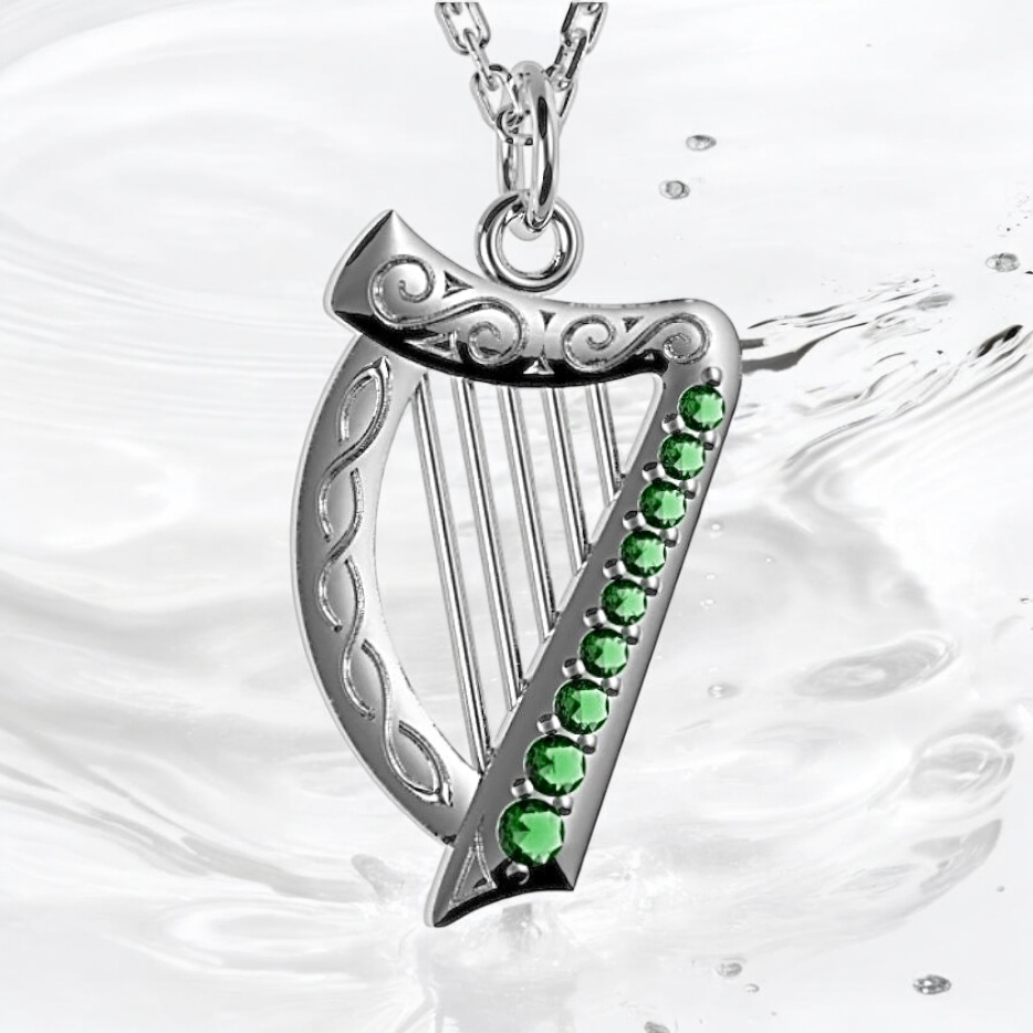 Sterling silver Celtic harp pendant inspired by Irish and Welsh heritage, perfect for harpists, with green gemstones. 